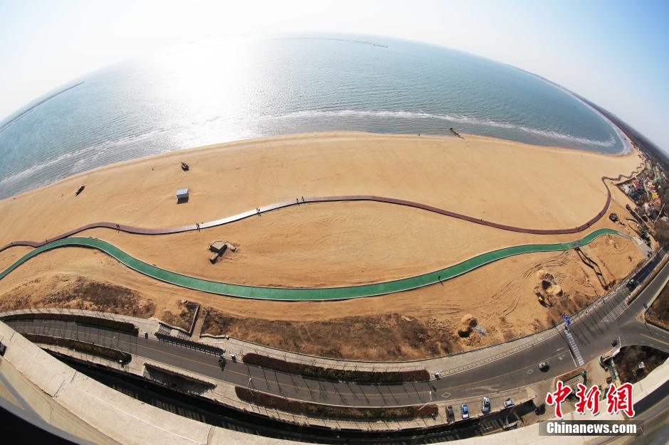 3月13日，秦皇島萬米臨海沙灘木棧道。據(jù)了解，該木棧道全長約4200米，與北戴河區(qū)原有的7500米木棧道對接后全線總長度1.17萬米，整個木棧道東起秦皇島體育基地游船碼頭，西至北戴河濕地公園，呈波浪形蜿蜒10.4公里海岸線。 中新社發(fā) 曹建雄 攝 CNSPHOTO
